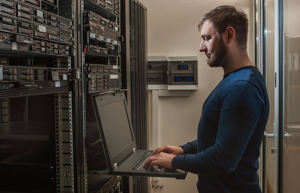 Network engineer working in server room.